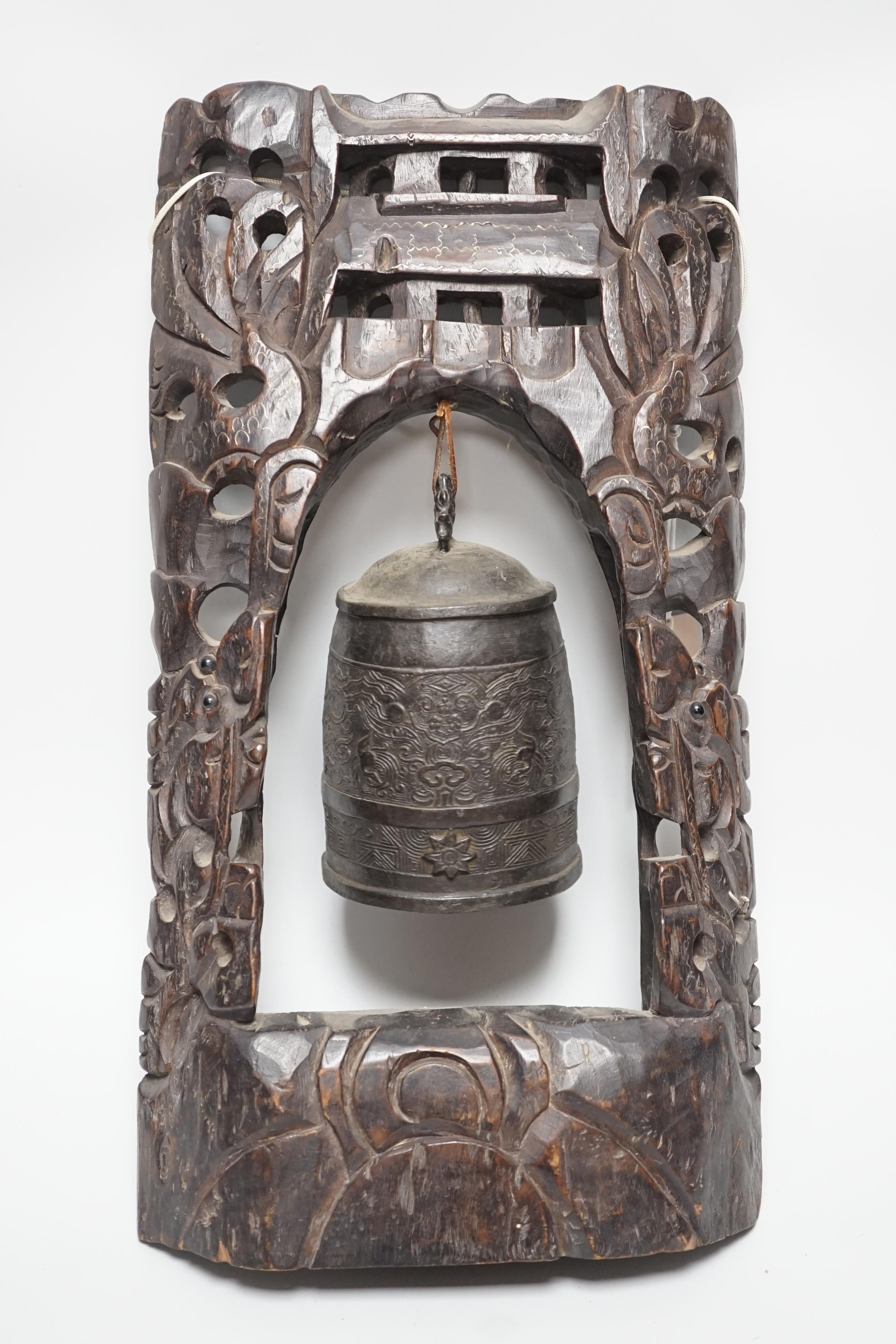 A Chinese bronze bell with wire inlaid carved hardwood stand, 44cm